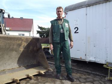 Mitarbeiter vor Frontladerschild